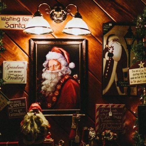 A painting of santa surrounded by festive decorations at Dudeck's Pine Country in Rolling Prairie, Indiana.