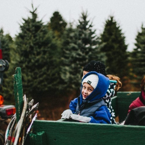 Kid smiling on a tractor ride at Dudeck's Pine Country in Rolling Prairie, Indiana.