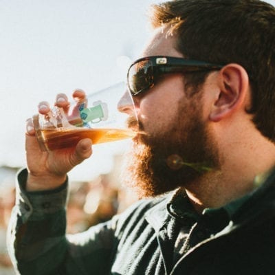 Bearded man drinking beer at Shelf Ice Brewfest in Michigan City, Indiana.