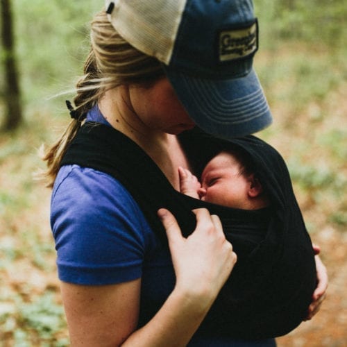 A young woman peeking at her newborn baby in Warren Woods State Park, Michigan.