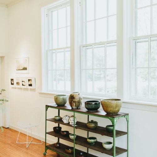 A collection of ceramics displayed on a vintage industrial console at Judith Racht Gallery in Harbert, Michigan.