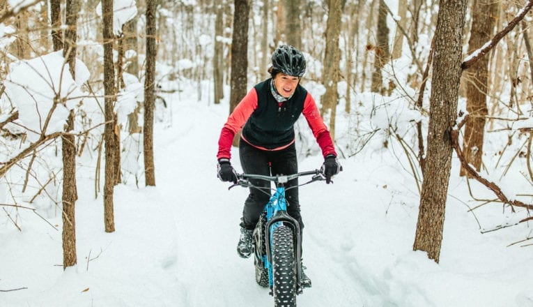 Riding a fat tire bike uphill through a snowy forest at Love Creek County Park in southwest Michigan.
