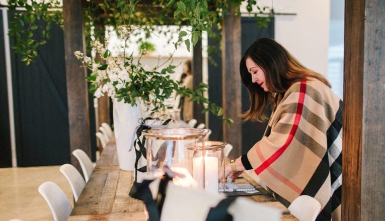 Wedding planner Jen Ederer preparing to style a dining table at her Soigne Retreat in Union Pier, Michigan.