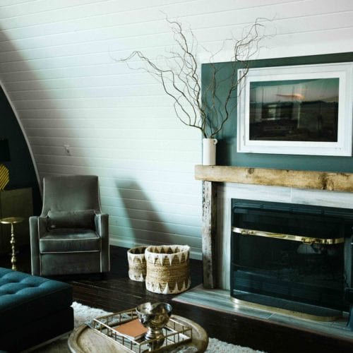 A cozy living room with wood-burning fireplace in Barn of Three Oaks vacation home in southwest Michigan.