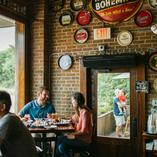 A young couple enjoying meal in the large front window of Greenbush Brewing in Sawyer, Michigan.