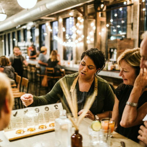 A server guiding a group through a whiskey tasting at Staymaker restaurant in Journeyman Distillery in Three Oaks, Michigan.