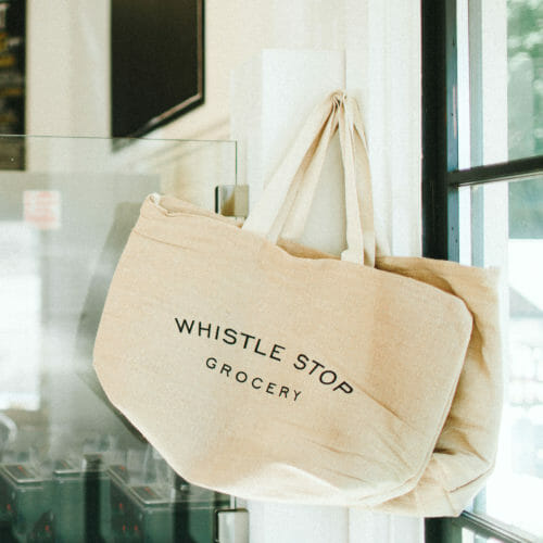 Natural canvas tote bags with Whistle Stop Grocery logo in Union Pier, Michigan.