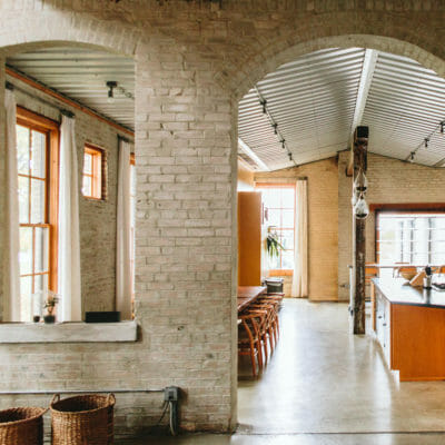 View into the kitchen through a wide, arched brick doorway at The Flat at Journeyman Distillery in Three Oaks, Michigan.