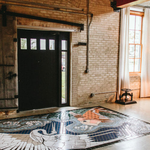 An artful tile mosaic 'rug' in the entry of The Flat at Journeyman Distillery in Three Oaks, Michigan.