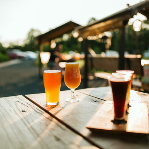 Beer in different colors and glass styles on a wooden table at River Saint Joe brewery in Buchanan, Michigan.