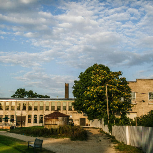 view of brick building facing staymaker with blue sky and clouds