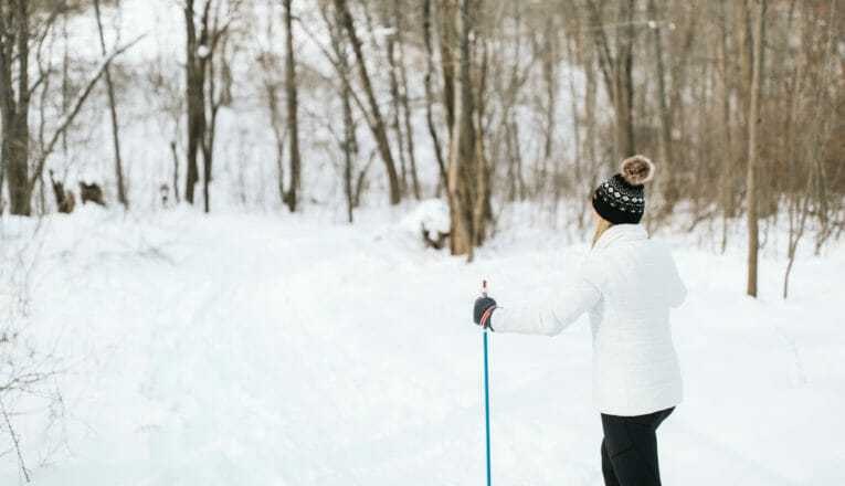 A woman cross-country skiing on a wooded trail in Warren Dunes State Park in Sawyer, Michigan.