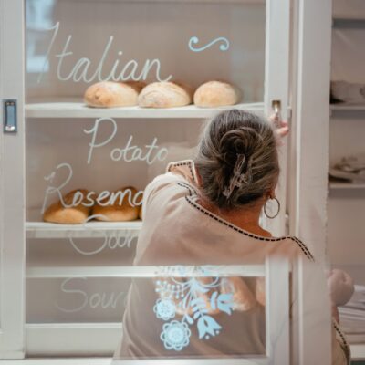 Woman arranging freshly baked bread at Harbert Swedish Bakery in Harbert, Michigan.