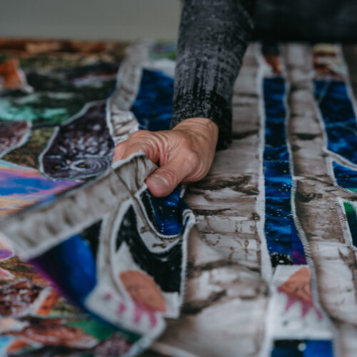 A woman's hand flips through various colorful textile pieces during Harbor Country Art Attack in southwest Michigan.