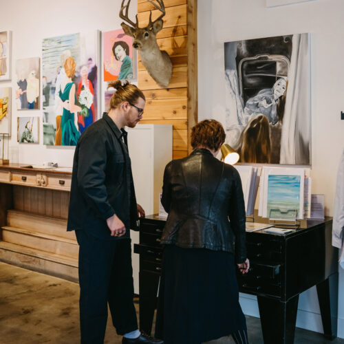 A man and a woman browse through art prints during Art Attack in New Buffalo, Michigan.