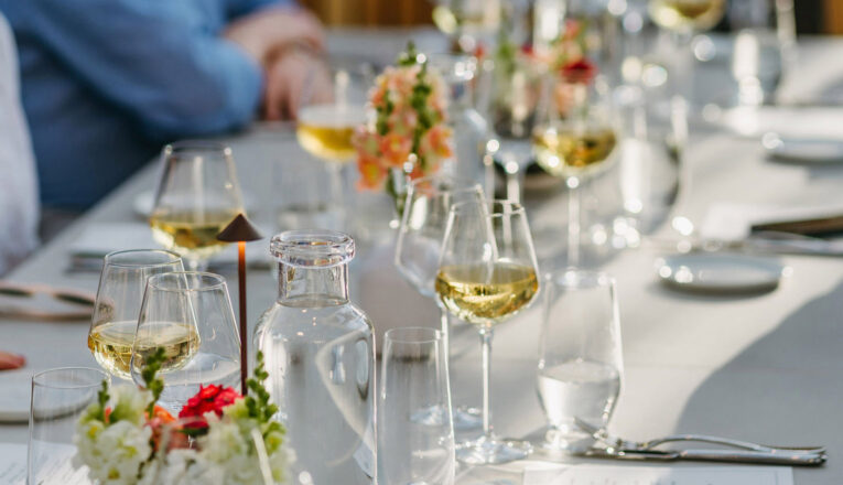 Long white tables set with wine-filled glasses at Granor Farm in Three Oaks, Michigan.