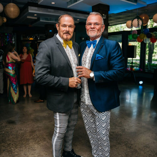 Two men in blazers and bowties pose for a photo at the Harbor Country Pride Prom event in Union Pier, Michigan.