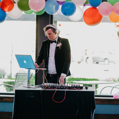 A DJ plays music under a canopy of balloons at the Harbor Country Pride Prom event in Union Pier, Michigan.