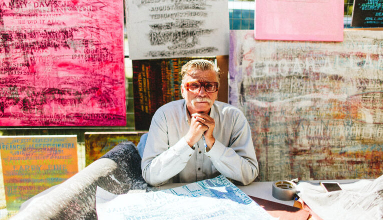 An artist with his brightly colored grave rubbings at Outsiders Outside Art Fair in Harbert, Michigan.