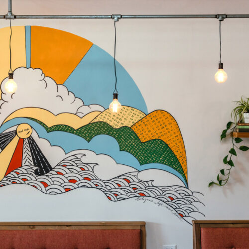 A colorful, sunny mural brightens up a cafe wall at Infusco Coffee Roasters in Sawyer, Michigan.