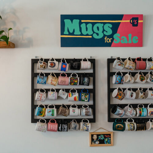 A wall display of colorful mugs for sale at Infusco Coffee Roasters in Sawyer, Michigan.