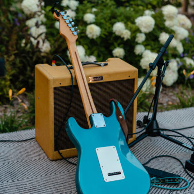 A blue guitar resting among stage equipment and hydrangea flowers at Susan's in Sawyer, Michigan.