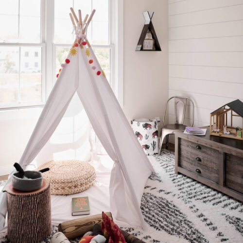A bedroom intended for younger guests with a play tipi, a plush fire pit, and other toys at Wandering Soul Cabin in Sawyer, Michigan.