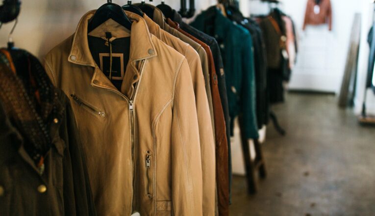 Leather moto jackets of different colors hung in a row at Goods & Heroes in Three Oaks, Michigan.