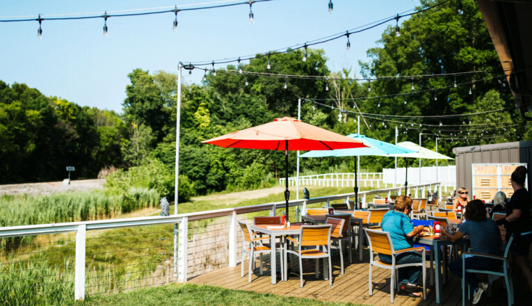 The sunny backyard and patio seating of Ghost Isle Brewery in New Buffalo, Michigan.