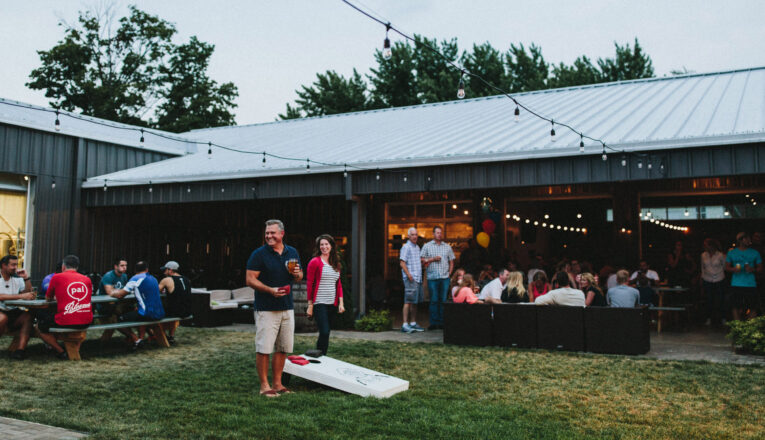 A couple plays corn hole in the lively outdoor area of Watermark Brewing Company in Stevensville, Michigan.