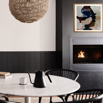 A white marble table with a black water kettle in front of a black fireplace with a framed textile above it at Marina Grand Resort in New Buffalo, Michigan.