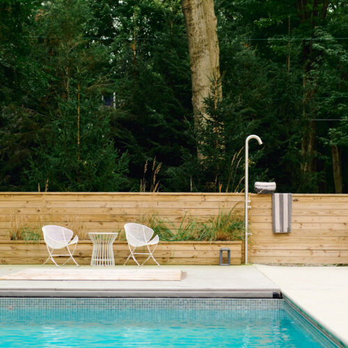 Minimal seating, an outdoor shower, and pool surrounded by nature at Sol Haus in Union Pier, Michigan.