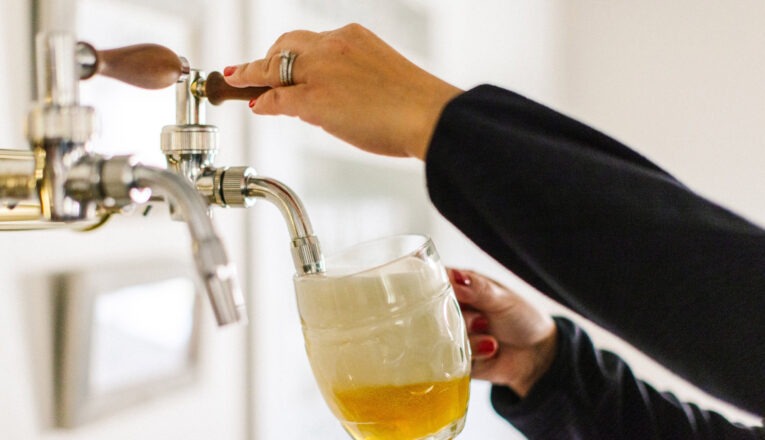 A woman pouring beer from a tap at Seedz Brewery in Union Pier, Michigan.