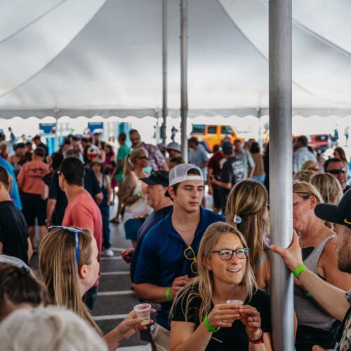 A crowd gathered underneath a white tent at Maker’s Trail Festival in Bridgman, Michigan.