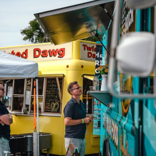 A man ordering from one of the colorful food trucks at Maker’s Trail Festival in Bridgman, Michigan.