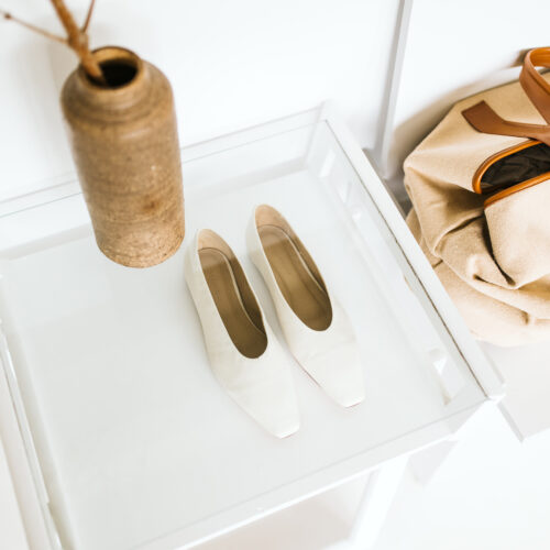 A single pair of white leather flats and a canvas weekender bag at AP Shops in Lakeside, Michigan