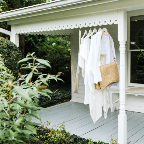 Linen tunics and a straw bag hang from the outdoor porch at AP Shops in Lakeside, Michigan.