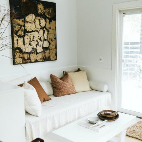 A bright living room with white furniture and earth-tone accessories at Shamrock House in Harbert, Michigan.