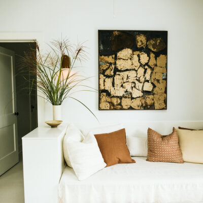 A bright living room with white furniture and earth-tone accessories at Shamrock House in Harbert, Michigan.