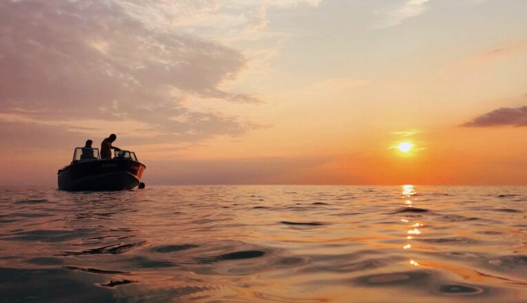 A motor boat anchored for a sunset swim in Lake Michigan.