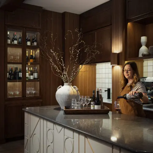 A bartender pouring a glass of wine behind the Living Room bar at Marina Grand Resort in New Buffalo, Michigan.