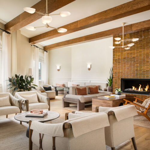 The brick fireplace and thoughtfully arranged seating areas in the Living Room at Marina Grand Resort in New Buffalo, Michigan.