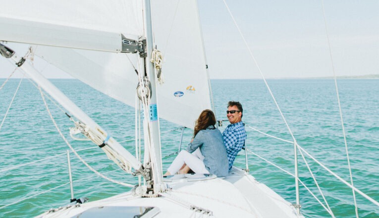 A couple enjoying the view from the bow of New Buffalo Sailing Excursions on Lake Michigan.