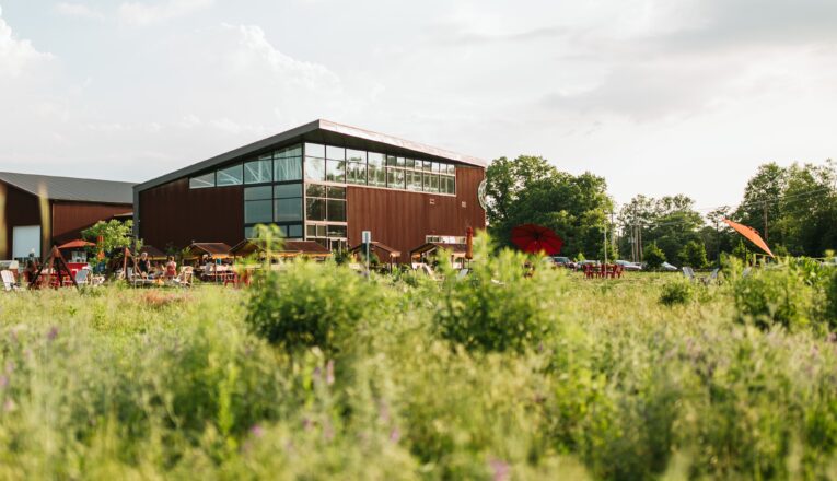 A striking glass and steel brewery surrounded by farmland at River Saint Joe in Buchanan, Michigan.