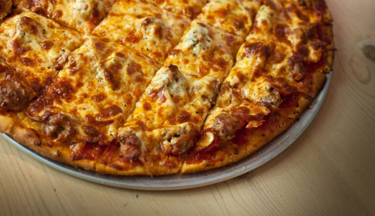 A close-up view of a fresh cheese pizza on a metal pan at Villa Nova Pizzeria in New Buffalo, Michigan.