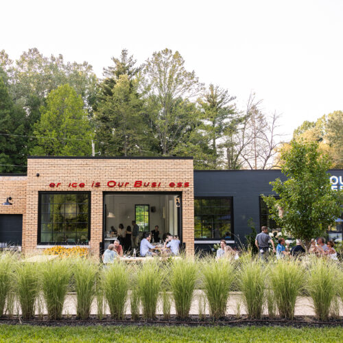 An exterior view of the building with outdoor seating and greenery.