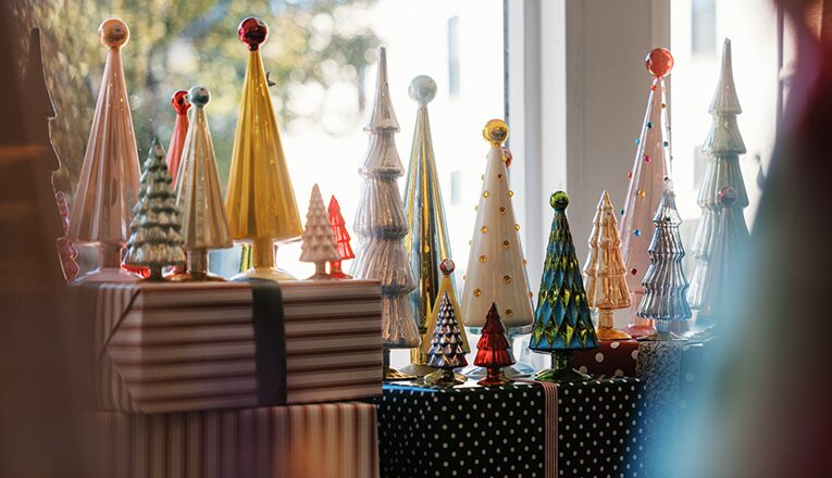 Multi-colored glass christmas trees on display and sparkling in the sun at Alapash New Home in Three Oaks, Michigan