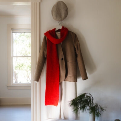 A knit outfits with a red scarf hangs on the wall next to an inside AP Shop in Lakeside, Michigan
