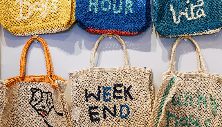 Straw bags with cheeky sayings hang on the wall at 108, a store in downtown New Buffalo, Michigan
