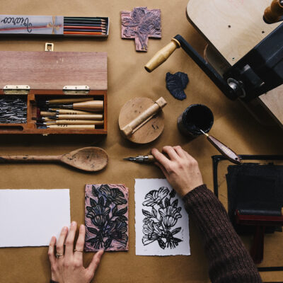 Hands working on a printmaking project at Handmade Studio in Three Oaks, Michigan